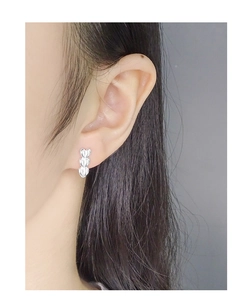 Close-up of triple stacked heart stud earrings in polished S925 sterling silver on model