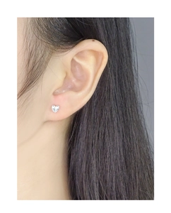 Close-up of S925 sterling silver asymmetrical heart earrings on a female model