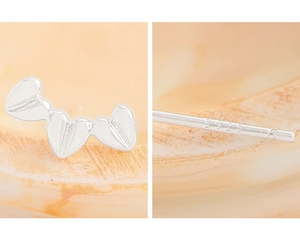 Macro detail of S925 sterling silver heart earrings with textured finish and hallmarking