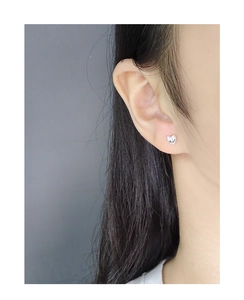 Close-up of minimalist S925 sterling silver asymmetric heart stud earrings on model