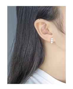 Close-up of S925 sterling silver asymmetric heart stud earrings worn on a model