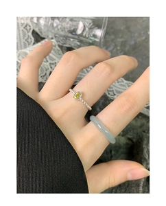 Detailed view of stacked silver beaded ring with green jade and grey agate band