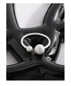 Macro shot of silver 925 open ring featuring matte brushed double sphere design details