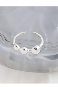 Macro shot of S925 sterling silver ring with polished beads on textured glass surface