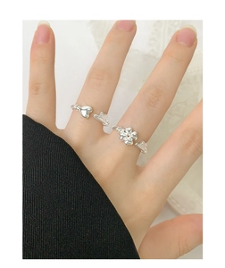 Detail of S925 silver adjustable ring featuring heart, key and clover charms on finger
