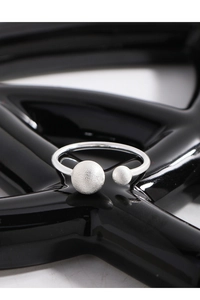 Close-up of S925 silver double ball open ring with matte brushed texture and polished band