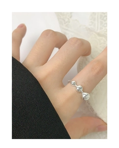 Close-up of a minimalist S925 sterling silver open ring with polished metal spheres on finger