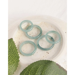 Set of five minimalist natural green jade rings in a ceramic tray for a high-end look