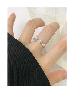 Detail of minimalist S925 sterling silver ring with three gradient metal balls on finger