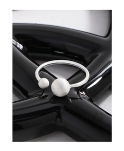 Macro view of adjustable S925 silver ring featuring dual matte brushed silver spheres