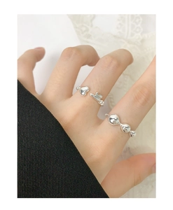 Detail of S925 sterling silver heart and bead rings worn by a model on white lace