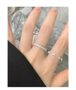 Close-up of S925 sterling silver daisy flower rings with small stones set on women's hand