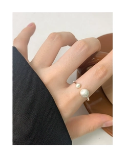Detail of matte brushed S925 sterling silver open ring with dual bead design on finger