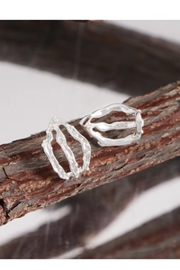 Macro detail of S925 sterling silver earrings with irregular textured organic lines