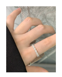 Close-up of S925 sterling silver flower ring with delicate beaded texture on woman finger
