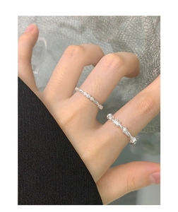 Close-up of S925 sterling silver rings set with floral motif and twisted bead texture