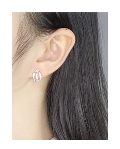 Close-up of a model wearing minimalist S925 sterling silver earrings with irregular texture