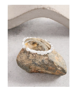 Detail of S925 sterling silver ring with beaded flower design on natural stone
