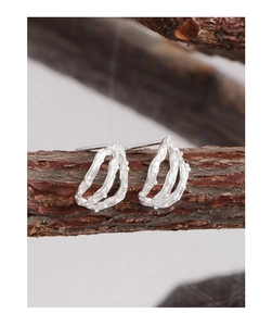 Close-up of S925 silver earrings with irregular organic texture on a dry branch