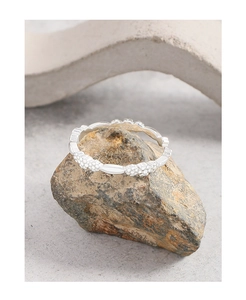 Macro shot of S925 sterling silver ring showing floral texture and hallmark on a stone