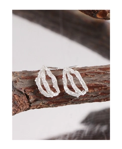 Detail of S925 sterling silver stud earrings with irregular wrinkled texture on tree bark