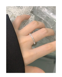 Close-up of S925 sterling silver floral ring band on hand with elegant lace background