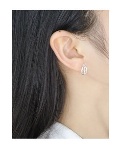 Close-up of irregular pleated texture silver earrings worn by a model in a minimal style