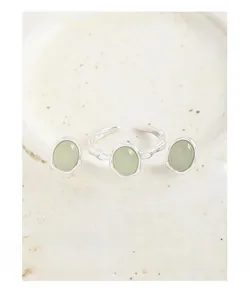 Dettaglio di anello e orecchini in argento S925 con pietra verde su piatto in ceramica