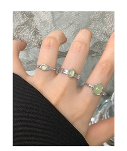 Set di anelli in argento S925 con cristalli verdi indossati sulla mano vista ravvicinata