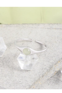 Detail of s925 silver ring featuring a round green crystal on ice-like display