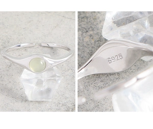 Macro detail of S925 sterling silver stamp on minimalist green crystal open ring