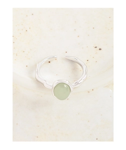 Dettaglio di un anello regolabile in argento martellato con una gemma verde ovale