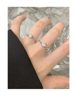 Close-up of S925 silver rings set with green and opal crystals on a model finger