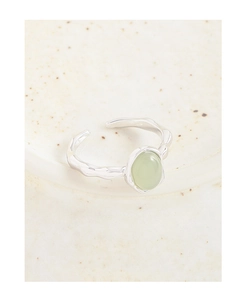 Dettaglio anello in argento S925 con pietra verde su una superficie di ceramica