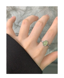 Dettaglio di un anello in argento s925 con cristallo verde ovale sulle dita