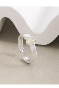 Detail of S925 silver adjustable ring with an oval green crystal and triple-layered band