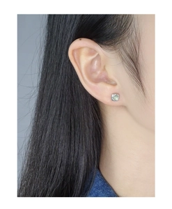 Close-up of S925 sterling silver pleated square earrings with green crystal gemstone