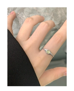 Close-up of S925 silver ring featuring a round green crystal on finger