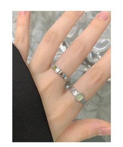 Close-up of S925 silver ring set featuring green crystal stones and layered bands