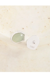 Detail view of S925 sterling silver stamp and light green translucent gemstone stud earrings