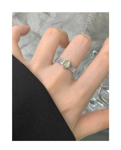 Detailed view of an S925 silver ring featuring a light green oval gemstone on a hand