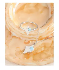 Vue macro d'un ensemble bague et collier étoile en argent S925 et opale bleue