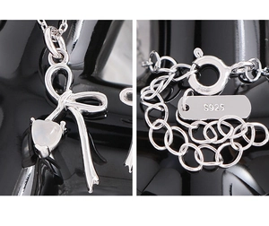 Makro-Detail der S925 Sterlingsilber-Schleifenkette mit herzförmigem weißem Achatstein