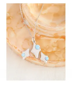 Macro shot of S925 sterling silver star pendant with blue opal and matching stud earrings