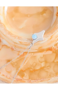 Macro view of S925 silver star pendant with light blue opal stone on a warm stone surface