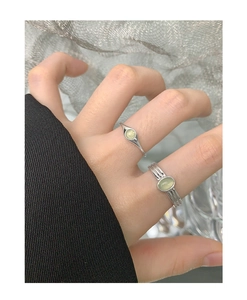 Detailed view of layered S925 silver rings featuring oval green crystal gemstones
