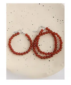 Detail of red agate bead bracelets with S925 silver lobster clasp on ceramic plate