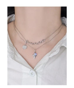 Close-up of double-layered silver necklace with star-shaped opal pendant and engraved tag