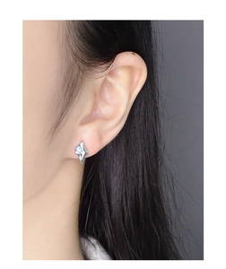 Close-up of S925 sterling silver star stud earring with blue opal stone on model's ear