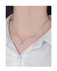 Detailed view of an S925 silver star pendant with blue opal worn on a white shirt